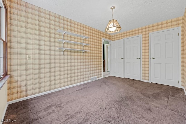12935 Robinwood St NE, Alliance, OH 44601 - unfurnished bedroom featuring wallpapered walls, carpet flooring, baseboards, a textured ceiling, and a closet