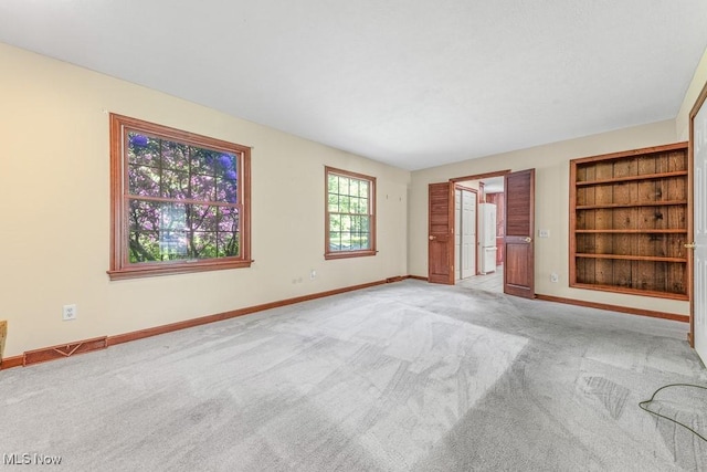 12935 Robinwood St NE, Alliance, OH 44601 - empty room with light colored carpet, baseboards, and built in features