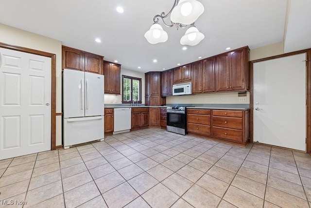 12935 Robinwood St NE, Alliance, OH 44601 - kitchen featuring white appliances, a sink, light tile patterned floors, a chandelier, and recessed lighting