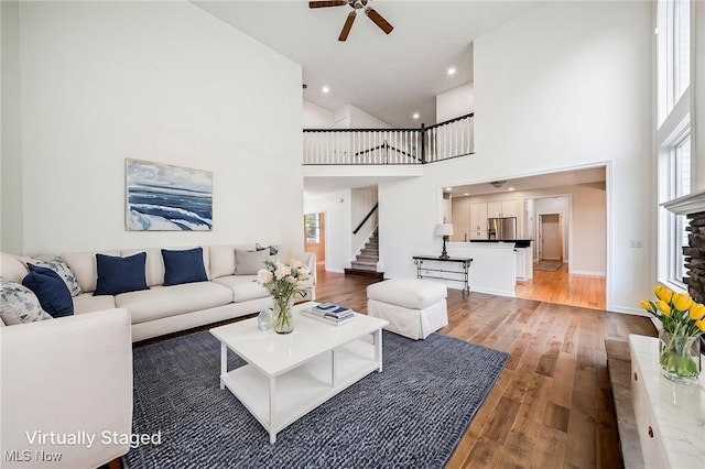 7776 Keystone Dr, Concord, OH 44077 - living area with a ceiling fan, healthy amount of natural light, light wood-style flooring, stairs, and a towering ceiling