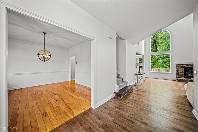 7776 Keystone Dr, Concord, OH 44077 - unfurnished living room with wood-type flooring, stairway, a chandelier, baseboards, and a fireplace