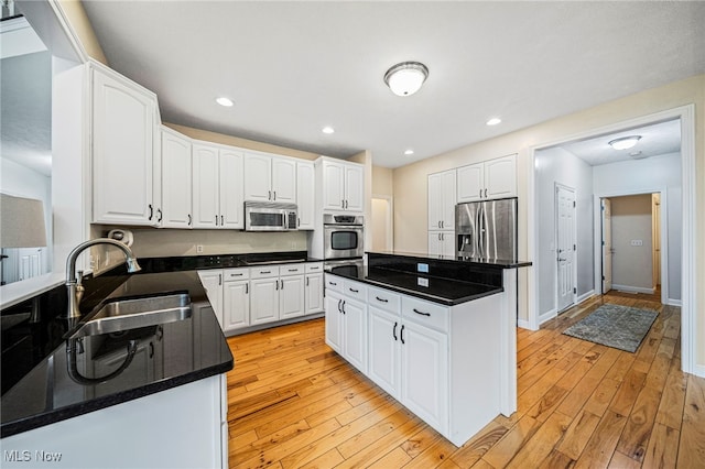 7776 Keystone Dr, Concord, OH 44077 - kitchen with appliances with stainless steel finishes, a sink, white cabinetry, light wood finished floors, and recessed lighting