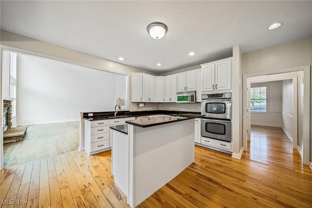 7776 Keystone Dr, Concord, OH 44077 - kitchen featuring stainless steel appliances, a sink, white cabinets, light wood-style flooring, and recessed lighting