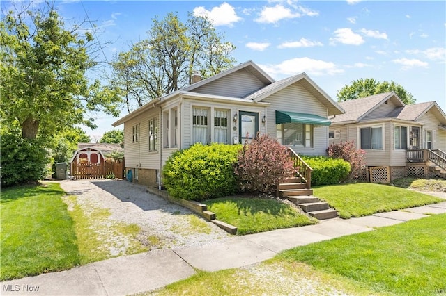226 N 19th St, Sebring, OH 44672 - bungalow-style home featuring a chimney, a front yard, and gravel driveway