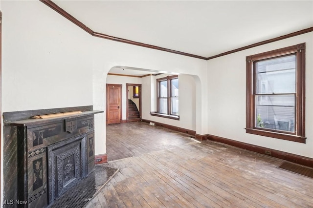 604 E Lincoln Way, Lisbon, OH 44432 - unfurnished living room with arched walkways, hardwood / wood-style floors, a fireplace, baseboards, and stairway