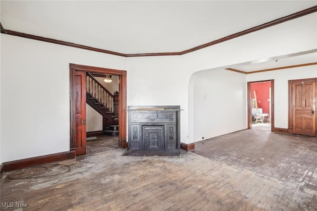 604 E Lincoln Way, Lisbon, OH 44432 - unfurnished living room with stairs, hardwood / wood-style floors, arched walkways, crown molding, and baseboards