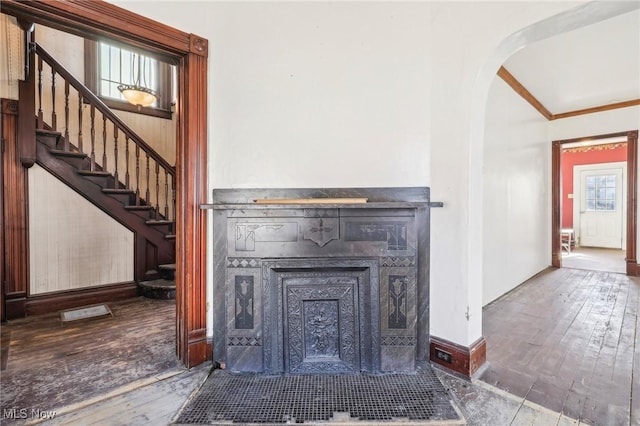 604 E Lincoln Way, Lisbon, OH 44432 - unfurnished living room with wood-type flooring, arched walkways, a fireplace with flush hearth, stairs, and ornamental molding