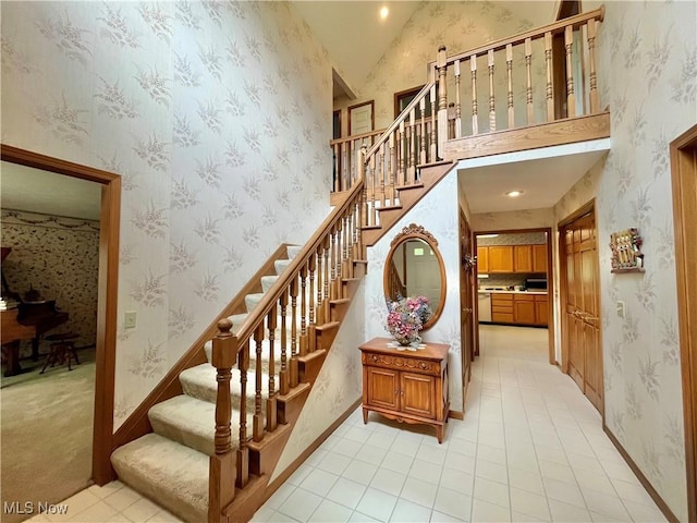 33939 Hanover Woods Trl, Solon, OH 44139 - staircase with wallpapered walls, tile patterned flooring, baseboards, and high vaulted ceiling