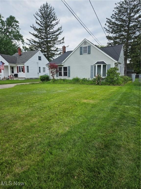 5102 Andrus Ave, North Olmsted, OH 44070 - view of home's exterior featuring a chimney and a lawn
