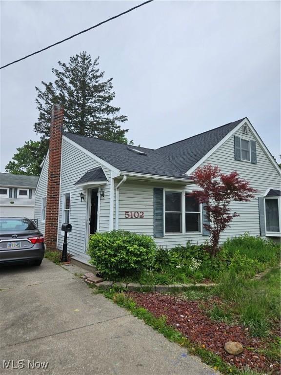 5102 Andrus Ave, North Olmsted, OH 44070 - view of front facade with roof with shingles and a chimney