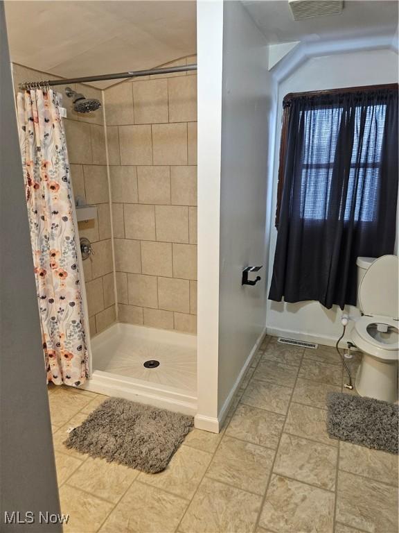 5102 Andrus Ave, North Olmsted, OH 44070 - full bath with a shower stall, toilet, baseboards, and tile patterned floors