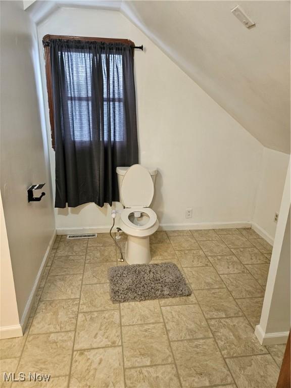 5102 Andrus Ave, North Olmsted, OH 44070 - bathroom featuring lofted ceiling, toilet, and baseboards