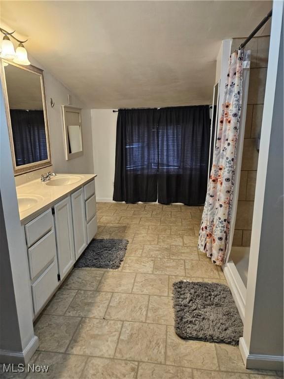 5102 Andrus Ave, North Olmsted, OH 44070 - full bath with double vanity, a shower stall, baseboards, and stone finish floors