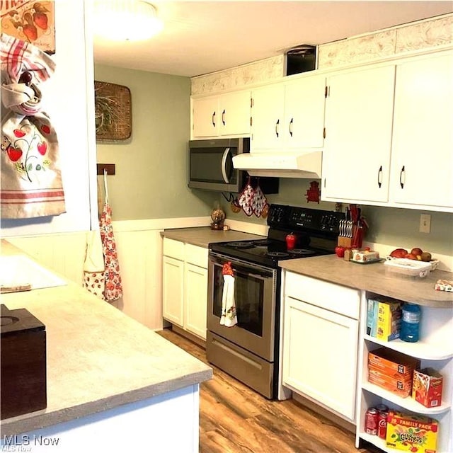71276 Old Twenty One St, Kimbolton, OH 43725 - kitchen with stainless steel appliances, under cabinet range hood, a wainscoted wall, light countertops, and light wood-type flooring