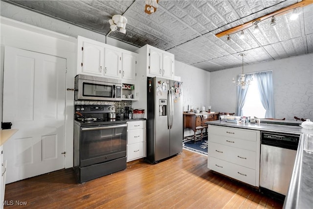28900 Euclid Ave, Wickliffe, OH 44092 - kitchen featuring stainless steel appliances, light wood-style flooring, white cabinets, hanging light fixtures, and a chandelier