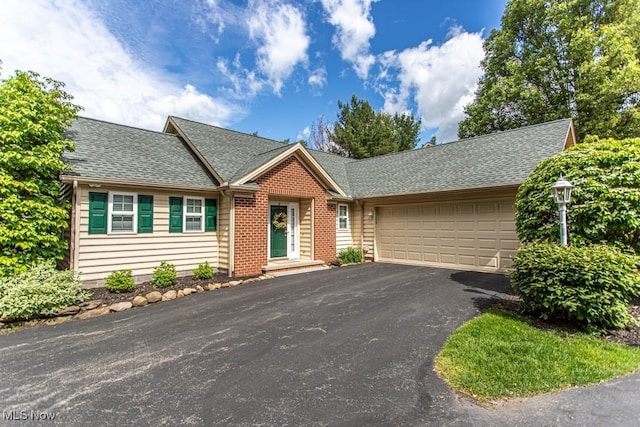 8121 Hitchcock Rd Unit 1, Youngstown, OH 44512 - view of front of property with an attached garage, asphalt driveway, and roof with shingles