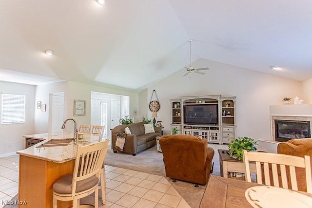 8121 Hitchcock Rd Unit 1, Youngstown, OH 44512 - living area with light tile patterned floors, light carpet, ceiling fan, vaulted ceiling, and a glass covered fireplace