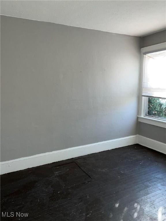 6701 Gertrude Ave, Cleveland, OH 44105 - spare room with baseboards and dark wood-style floors