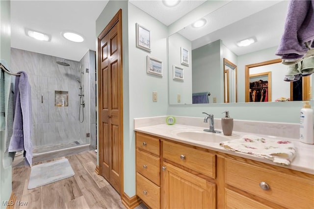 9903 Vermilion Rd, Amherst, OH 44001 - bathroom with a shower stall, vanity, wood finished floors, and a walk in closet