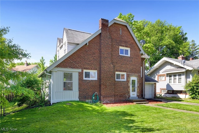 1608 Pilgrim St, Akron, OH 44305 - view of home's exterior featuring board and batten siding, a chimney, a lawn, and an attached garage