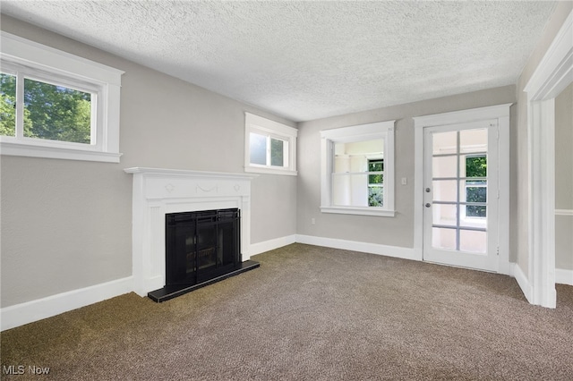 1608 Pilgrim St, Akron, OH 44305 - unfurnished living room with dark carpet, a fireplace with raised hearth, plenty of natural light, and a textured ceiling
