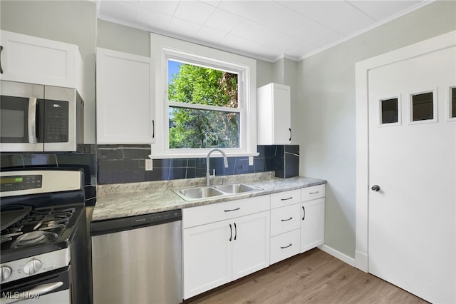1608 Pilgrim St, Akron, OH 44305 - kitchen featuring stainless steel appliances, a sink, decorative backsplash, white cabinets, and wood finished floors