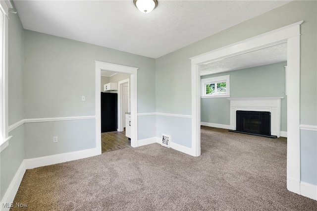 1608 Pilgrim St, Akron, OH 44305 - unfurnished living room with carpet, a fireplace with raised hearth, baseboards, and a textured ceiling