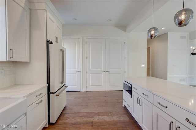 2540 Edgewood Trce, Pepper Pike, OH 44124 - kitchen featuring white refrigerator, built in microwave, wood finished floors, white cabinetry, and pendant lighting
