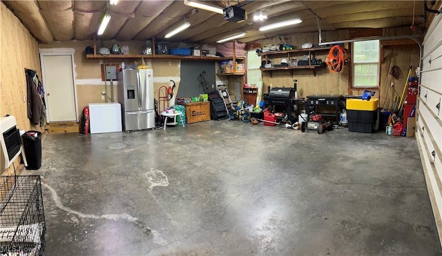645 Arends Ridge Rd, Marietta, OH 45750 - garage with stainless steel fridge with ice dispenser, heating unit, and a garage door opener