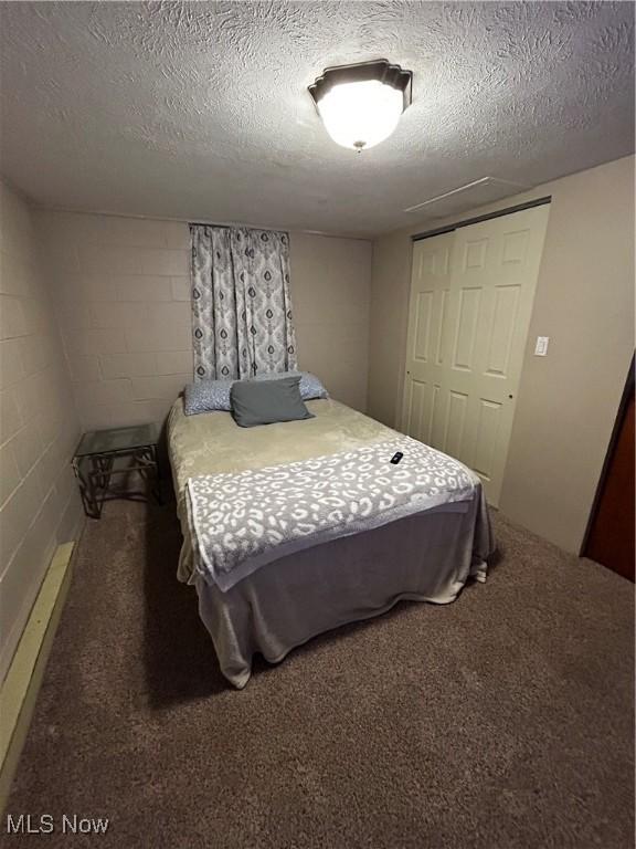 645 Arends Ridge Rd, Marietta, OH 45750 - carpeted bedroom with concrete block wall and a textured ceiling