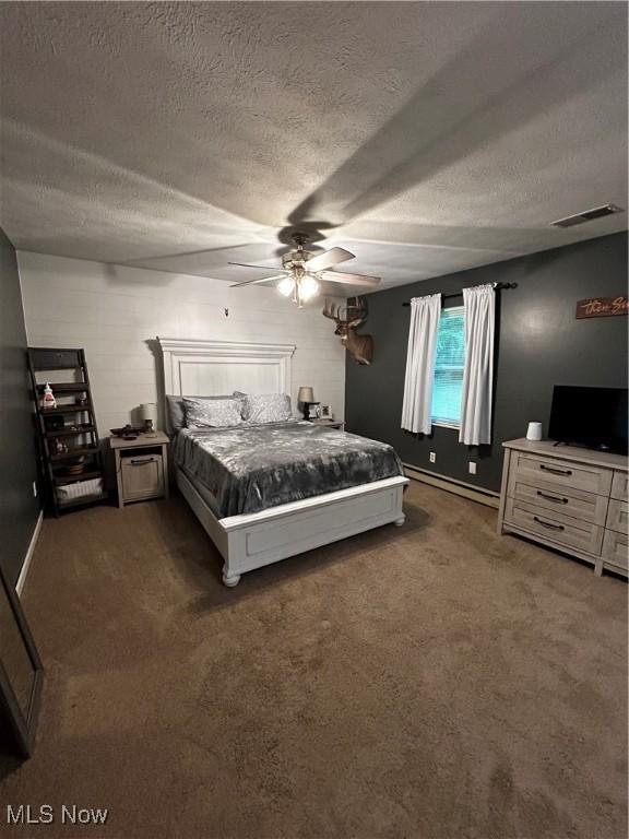 645 Arends Ridge Rd, Marietta, OH 45750 - carpeted bedroom with a textured ceiling, a baseboard heating unit, and ceiling fan