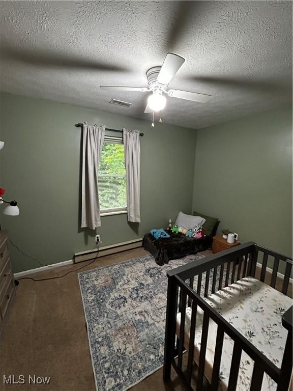 645 Arends Ridge Rd, Marietta, OH 45750 - carpeted bedroom with a baseboard radiator, baseboards, a ceiling fan, and a textured ceiling
