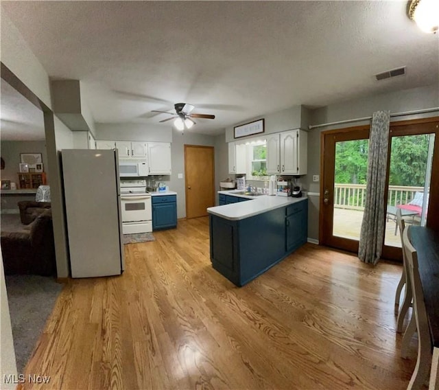 645 Arends Ridge Rd, Marietta, OH 45750 - kitchen featuring white appliances, a peninsula, white cabinets, light wood finished floors, and a textured ceiling