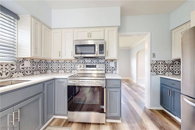 226 Cunningham Ln, Steubenville, OH 43952 - kitchen featuring appliances with stainless steel finishes, gray cabinets, tasteful backsplash, light countertops, and light wood finished floors