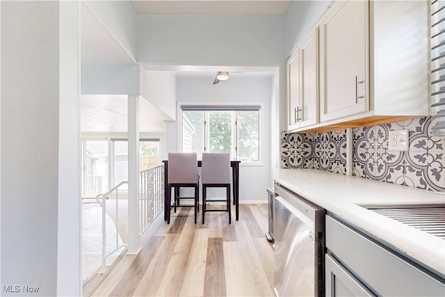 226 Cunningham Ln, Steubenville, OH 43952 - kitchen with stainless steel dishwasher, light wood-style flooring, light countertops, backsplash, and white cabinetry