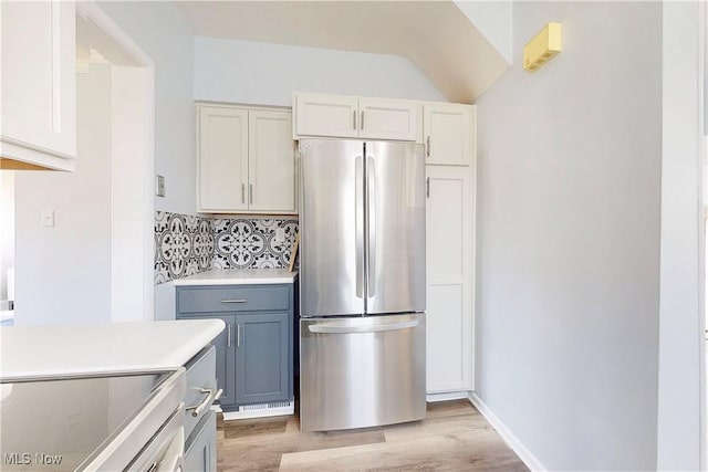 226 Cunningham Ln, Steubenville, OH 43952 - kitchen with freestanding refrigerator, light wood-style floors, decorative backsplash, light countertops, and lofted ceiling