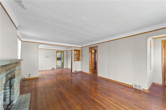 1613 Wexford Ave, Parma, OH 44134 - unfurnished living room with arched walkways, hardwood / wood-style floors, baseboards, and a brick fireplace