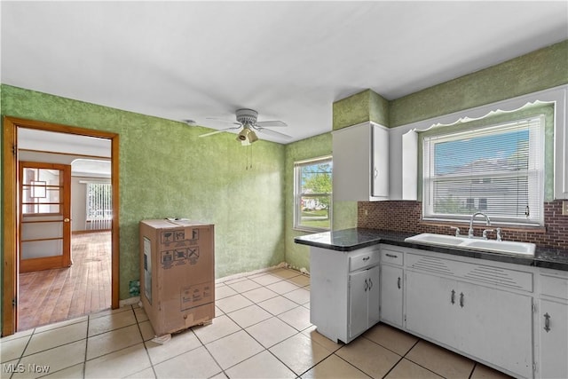1613 Wexford Ave, Parma, OH 44134 - kitchen with a sink, white cabinetry, dark countertops, ceiling fan, and decorative backsplash