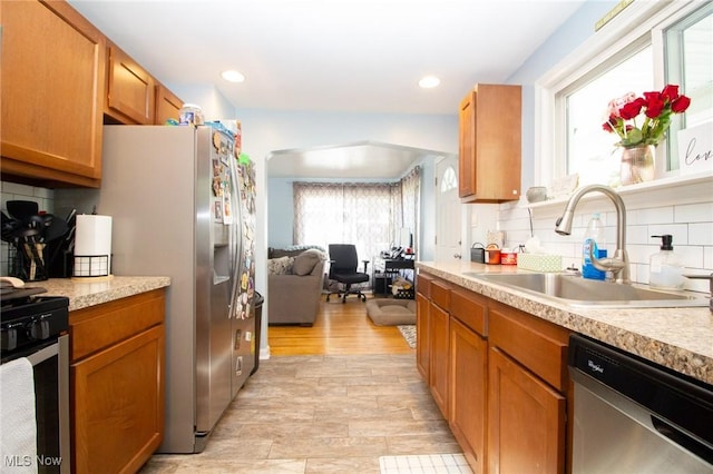 2464 Lyon Blvd, Poland, OH 44514 - kitchen featuring a sink, appliances with stainless steel finishes, light countertops, tasteful backsplash, and brown cabinetry