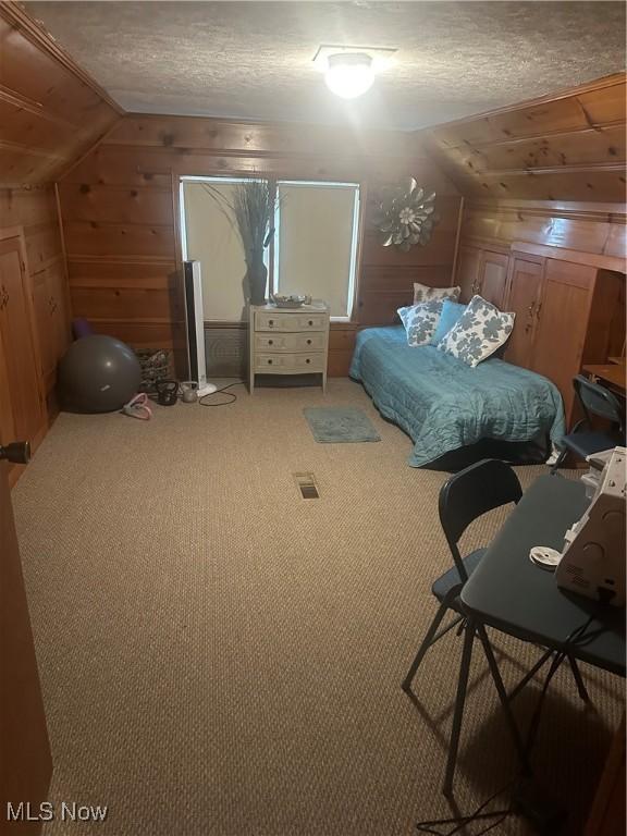 12704 Oak Park Blvd, Garfield Heights, OH 44125 - carpeted bedroom featuring wood walls, a textured ceiling, and lofted ceiling
