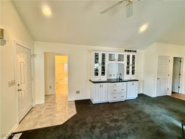 5228 Nashua Dr, Austintown, OH 44515 - kitchen featuring vaulted ceiling, white cabinetry, glass insert cabinets, a ceiling fan, and baseboards