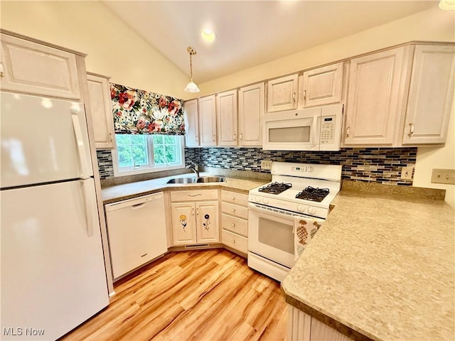 5228 Nashua Dr, Austintown, OH 44515 - kitchen with white appliances, a sink, light wood finished floors, vaulted ceiling, and decorative backsplash