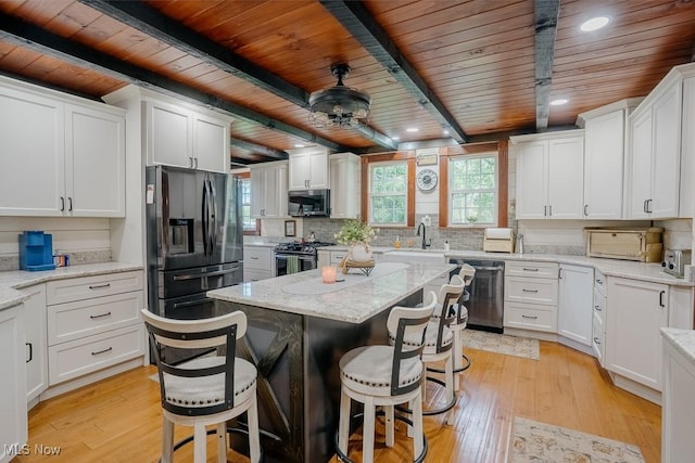2953 State Route 225, Diamond, OH 44412 - kitchen with appliances with stainless steel finishes, wooden ceiling with exposed beams, light wood-style floors, a breakfast bar, and white cabinetry