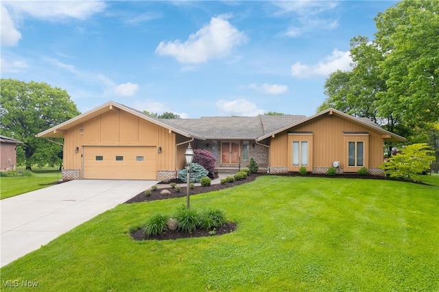 3751 Muirfield Dr, Uniontown, OH 44685 - view of front facade with board and batten siding, an attached garage, driveway, and a front lawn