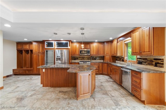 3751 Muirfield Dr, Uniontown, OH 44685 - kitchen featuring stainless steel appliances, brown cabinets, a kitchen island, dark stone counters, and backsplash