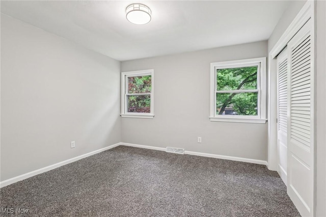 7558 E Parkside Dr, Boardman, OH 44512 - unfurnished bedroom with carpet floors, multiple windows, and a closet