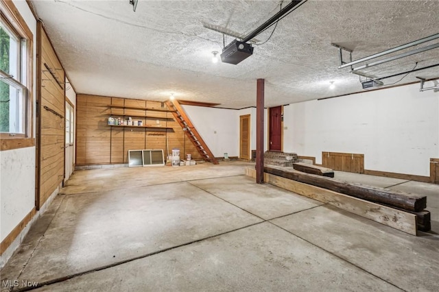 7558 E Parkside Dr, Boardman, OH 44512 - garage featuring a garage door opener, wooden walls, and baseboards