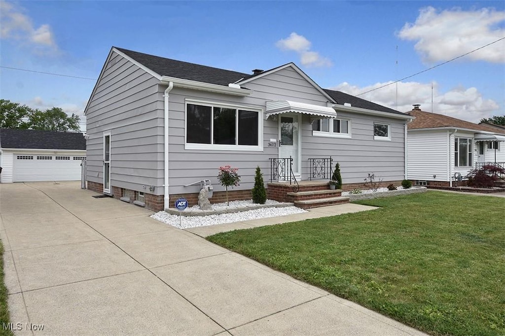 3612 Center Dr, Parma, OH 44134 - view of front facade featuring a front yard, an outdoor structure, a garage, and roof with shingles