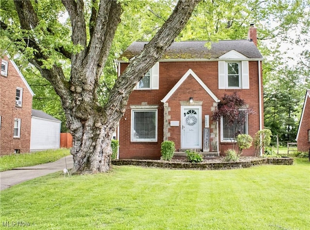 6892 Glenwood Ave, Youngstown, OH 44512 - view of front of house with a chimney, a front yard, and brick siding