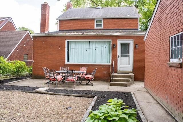 6892 Glenwood Ave, Youngstown, OH 44512 - rear view of property featuring a patio, brick siding, a chimney, a shingled roof, and entry steps